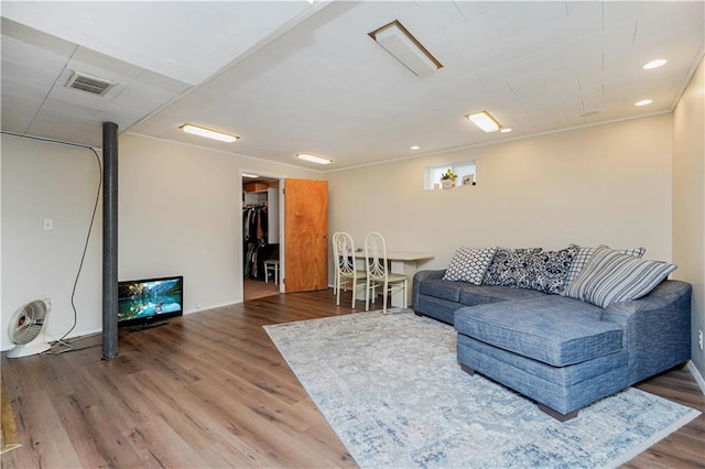 living area featuring baseboards, visible vents, wood finished floors, and recessed lighting