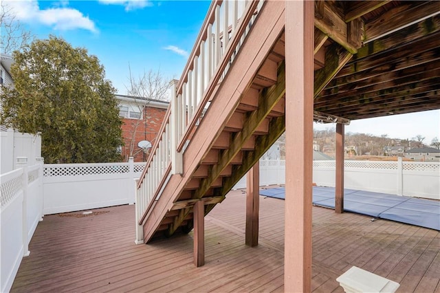 wooden terrace featuring fence and stairway