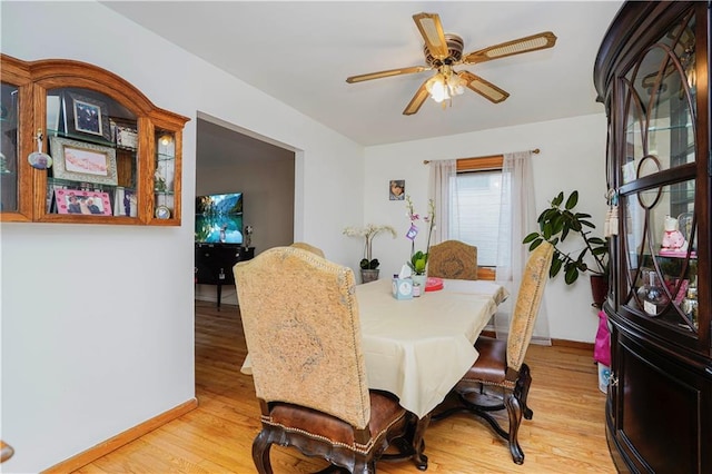 dining room featuring ceiling fan, light wood-style flooring, and baseboards