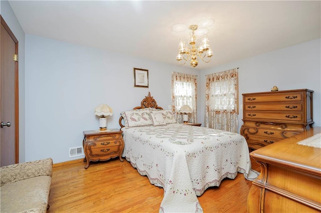 bedroom featuring a notable chandelier and light wood-style floors