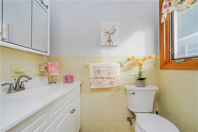 half bathroom featuring toilet, tile walls, and vanity