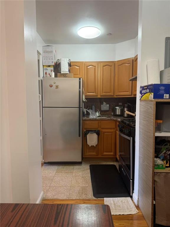 kitchen featuring brown cabinets, stainless steel appliances, and dark stone countertops