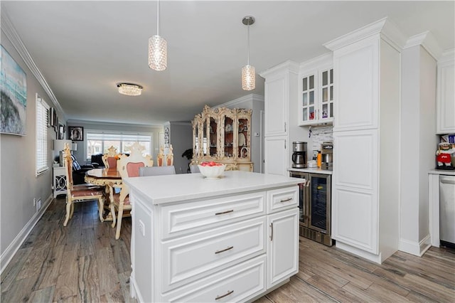 kitchen with light wood-style flooring, light countertops, and ornamental molding