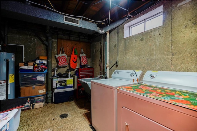 laundry area with visible vents, a sink, water heater, separate washer and dryer, and laundry area