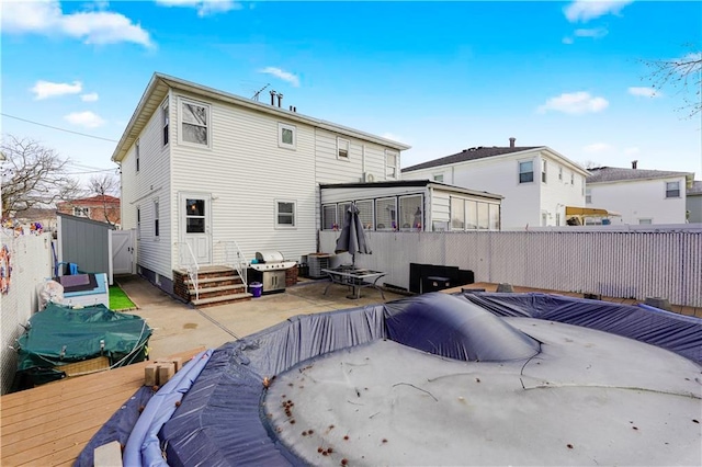 back of house with a wooden deck, central AC, and a fenced backyard