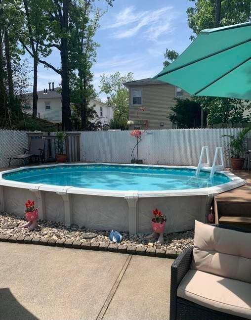 pool with a patio and fence