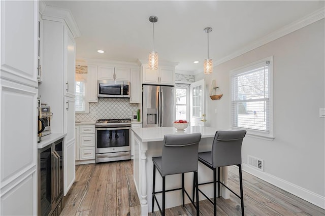 kitchen with visible vents, backsplash, appliances with stainless steel finishes, and white cabinetry