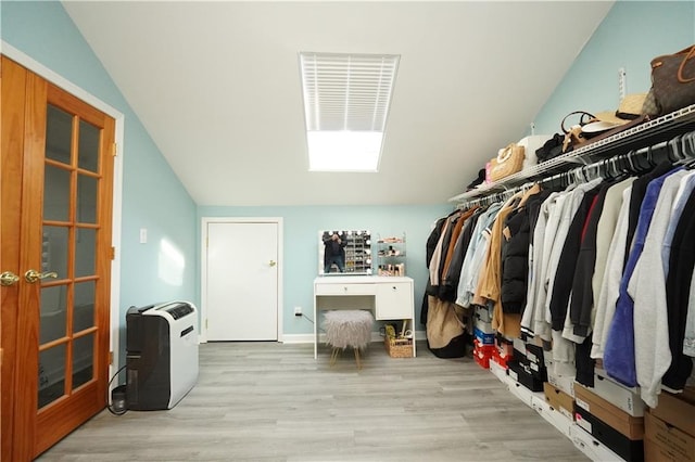 walk in closet featuring lofted ceiling and wood finished floors