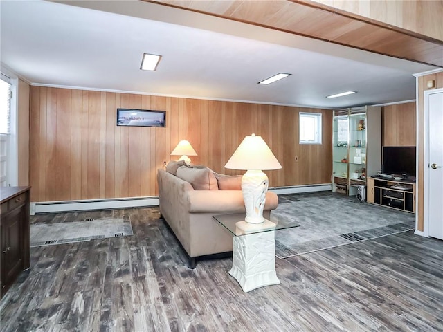 living room featuring wooden walls, baseboard heating, and wood finished floors