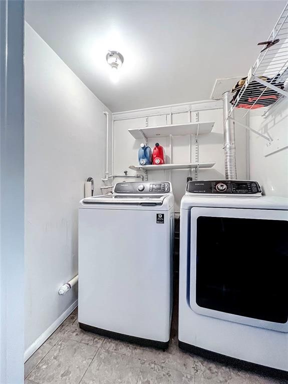 laundry area with baseboards, laundry area, and washer and dryer