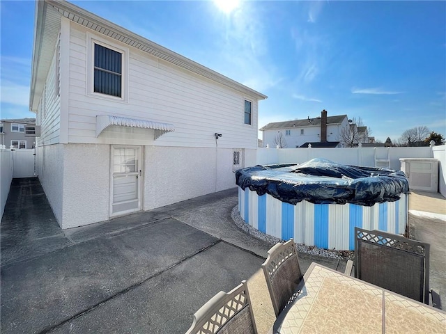 view of property exterior featuring a patio, a fenced backyard, a fenced in pool, and stucco siding