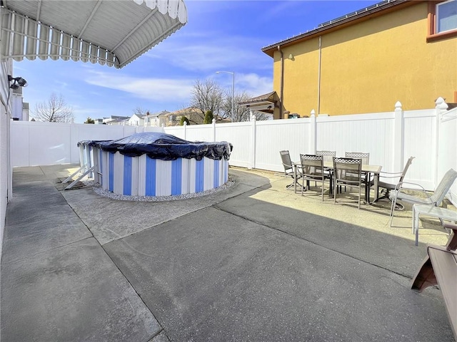 view of patio with a fenced backyard, outdoor dining area, and a fenced in pool