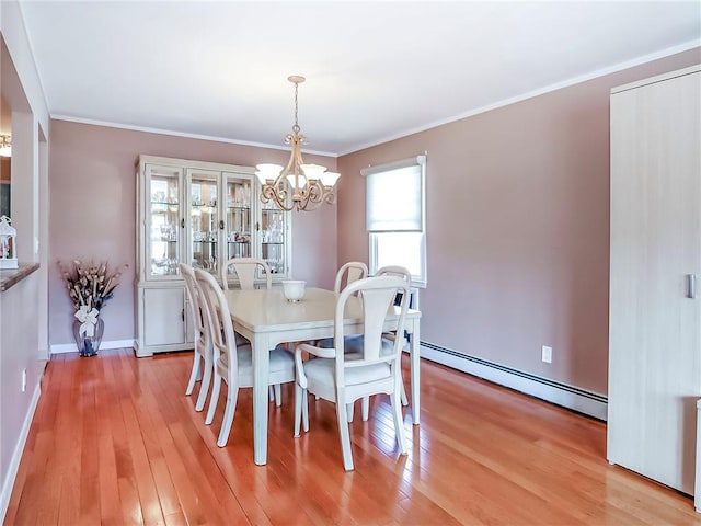 dining area with a chandelier, a baseboard radiator, crown molding, and light wood-style flooring