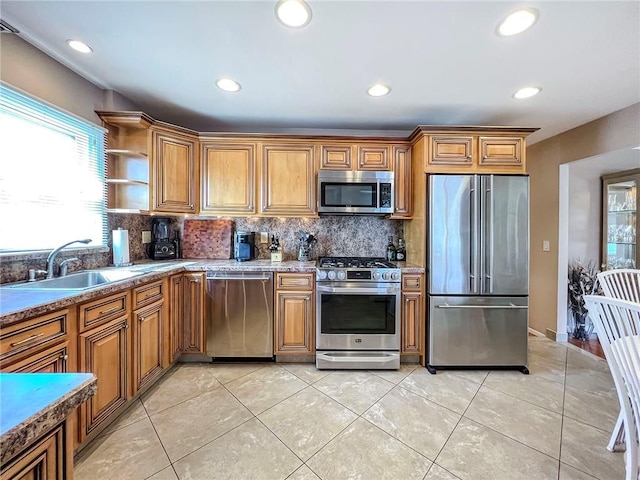 kitchen featuring decorative backsplash, appliances with stainless steel finishes, brown cabinets, and a sink