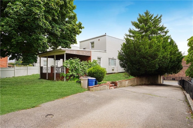 view of front of house with a front yard and fence