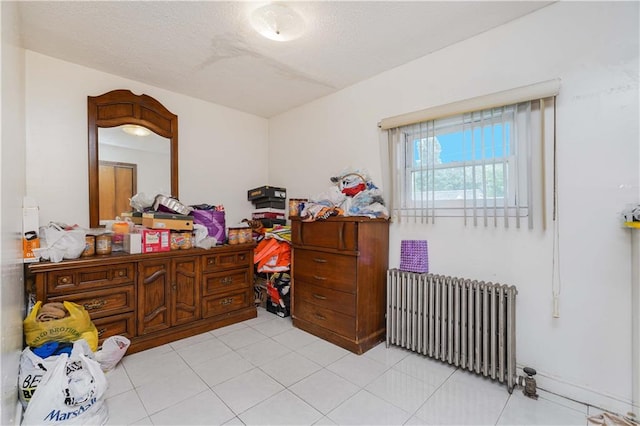 bedroom featuring radiator heating unit and light tile patterned floors