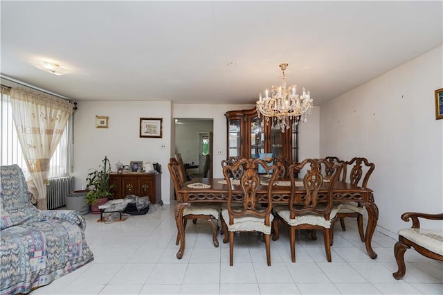 dining space featuring radiator heating unit and a notable chandelier