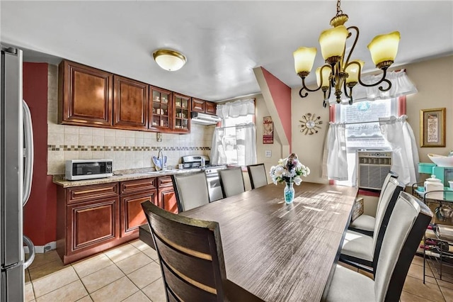 dining space with a notable chandelier, cooling unit, and light tile patterned flooring