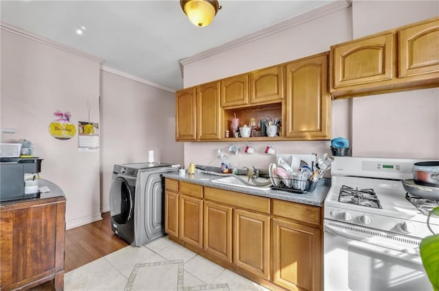 kitchen featuring crown molding, brown cabinets, a sink, light tile patterned floors, and white range with gas cooktop