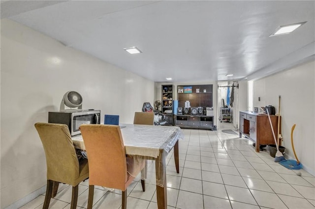 dining space featuring light tile patterned floors and baseboards