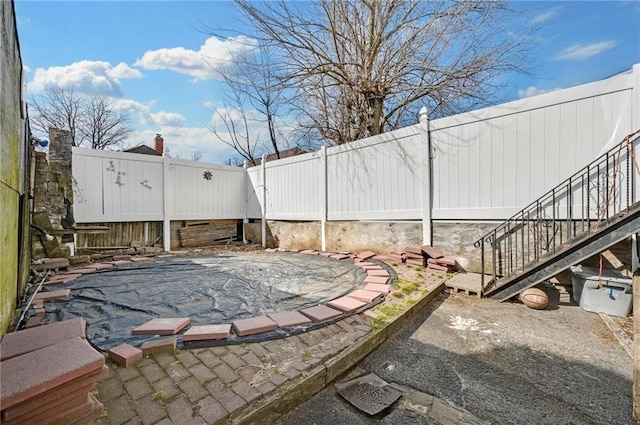 view of patio with fence and stairs