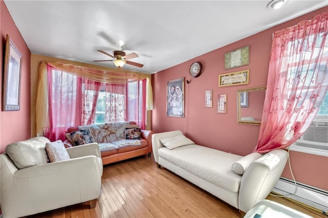 living room featuring ceiling fan, baseboard heating, and light wood-style flooring