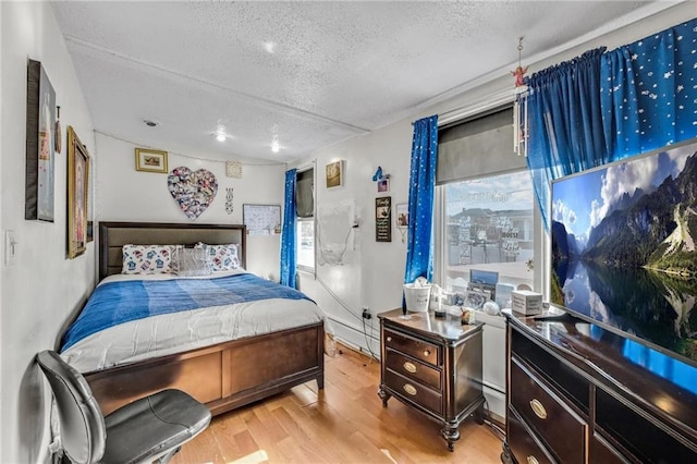 bedroom featuring a textured ceiling and wood finished floors