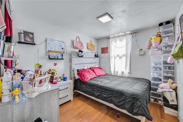 bedroom with a textured ceiling and wood finished floors