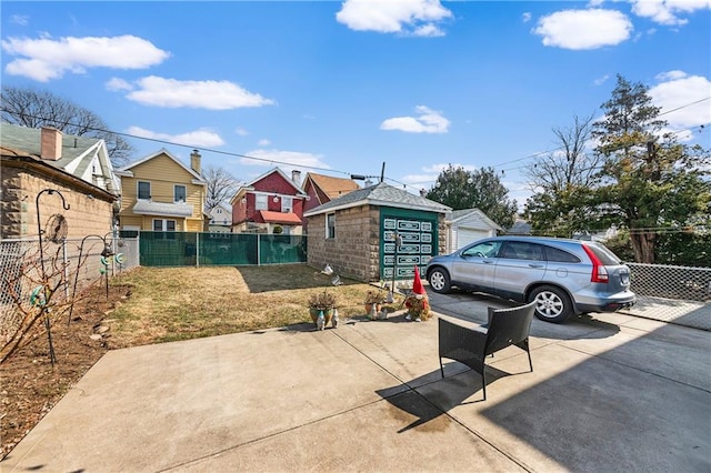 view of patio / terrace featuring fence private yard, an outdoor structure, and driveway