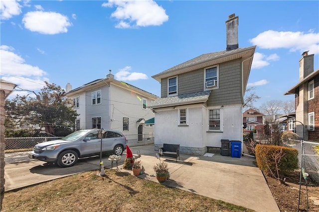 back of house with stucco siding, a shingled roof, a patio area, fence, and cooling unit