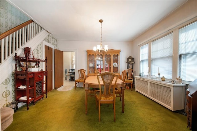 carpeted dining room with an inviting chandelier, stairway, and wallpapered walls