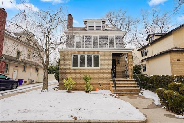 american foursquare style home with brick siding and a chimney