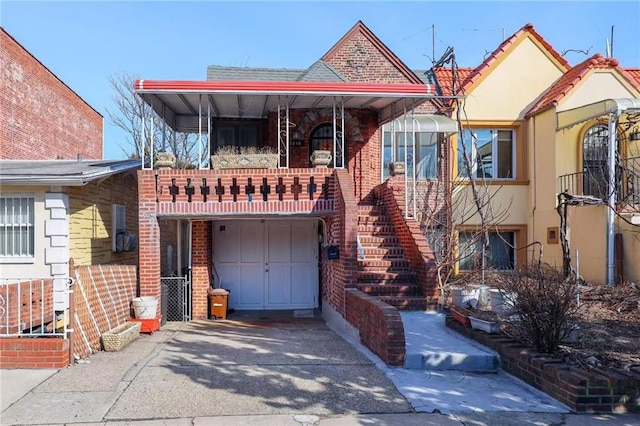 view of front facade with a garage, brick siding, concrete driveway, and stairs