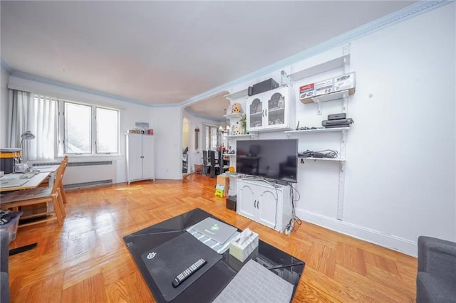 living room featuring radiator heating unit, baseboards, arched walkways, and ornamental molding