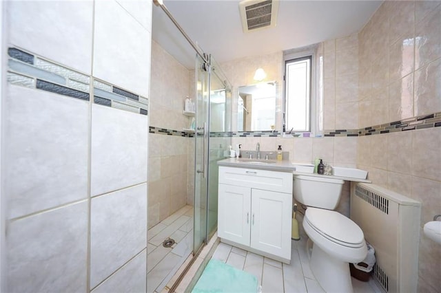 bathroom with visible vents, toilet, radiator heating unit, a stall shower, and tile walls