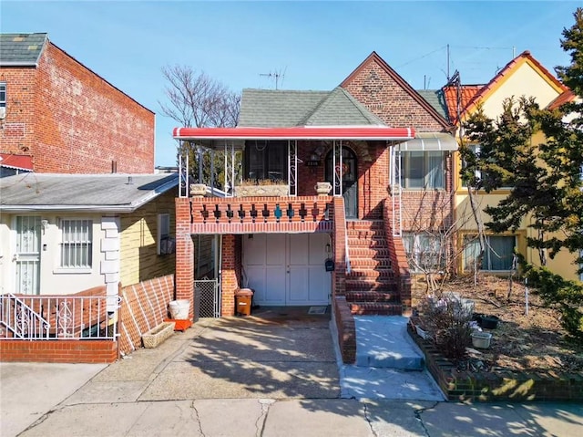 view of front facade with stairway, an attached garage, brick siding, and driveway