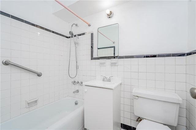 bathroom featuring toilet, shower / washtub combination, tile walls, and vanity