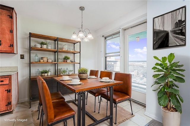 dining area with a notable chandelier, baseboards, and light tile patterned floors