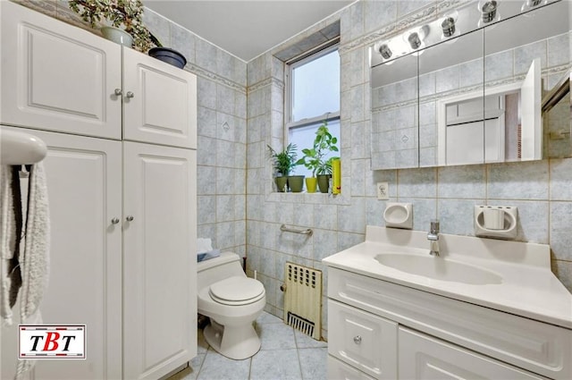 bathroom featuring tile walls, toilet, radiator heating unit, vanity, and tile patterned flooring