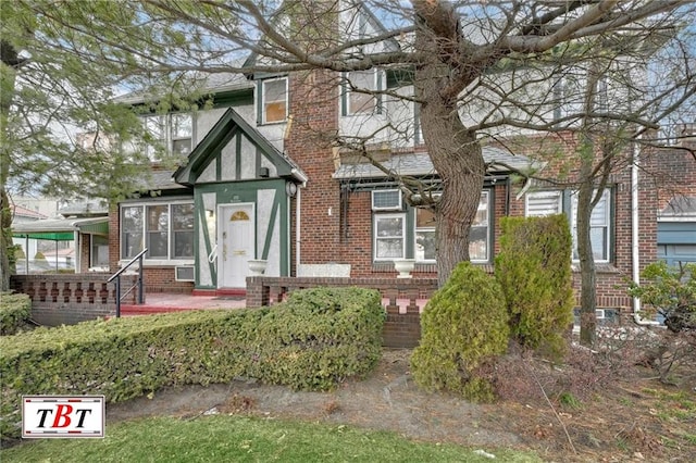 tudor house featuring brick siding and stucco siding