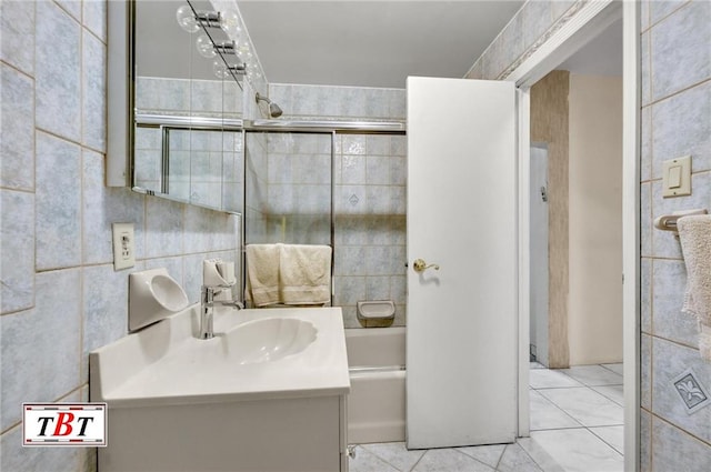 bathroom with tile patterned flooring, tub / shower combination, tile walls, and vanity