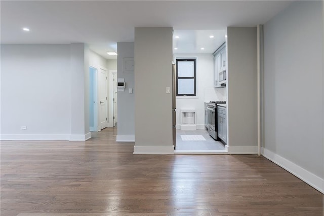 empty room featuring recessed lighting, baseboards, and wood finished floors