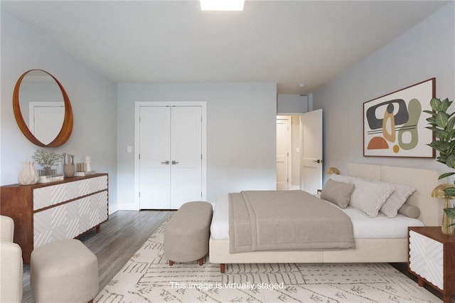 bedroom with a closet, baseboards, and wood finished floors