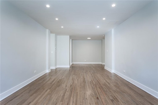 unfurnished room with recessed lighting, wood finished floors, and baseboards