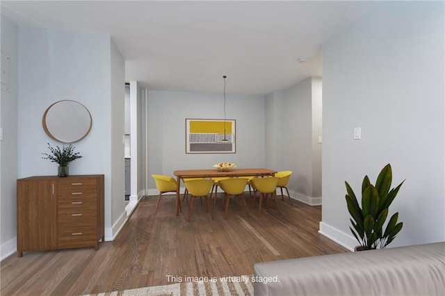 dining space featuring wood finished floors and baseboards