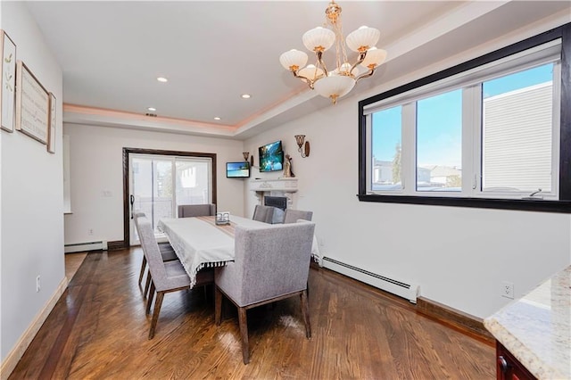 dining space with a baseboard heating unit, wood finished floors, baseboards, baseboard heating, and a raised ceiling