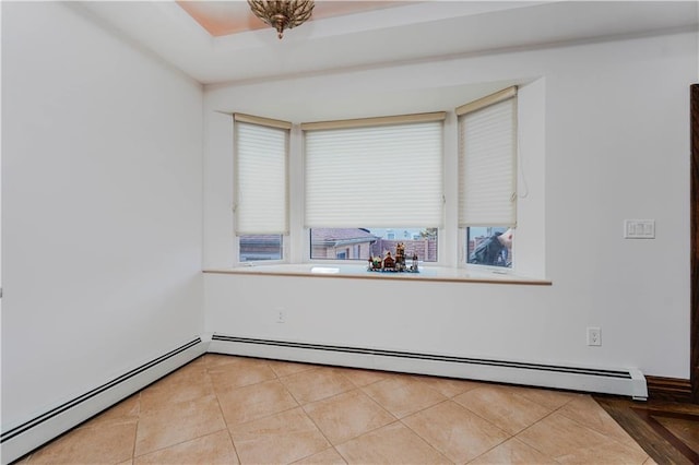 spare room featuring light tile patterned floors and a baseboard heating unit