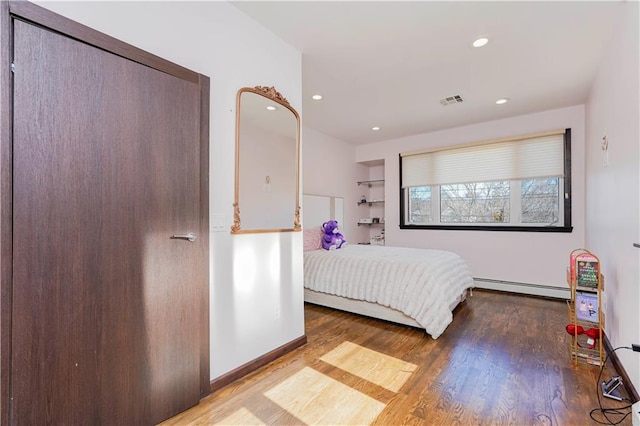 bedroom with baseboards, visible vents, a baseboard radiator, wood finished floors, and recessed lighting