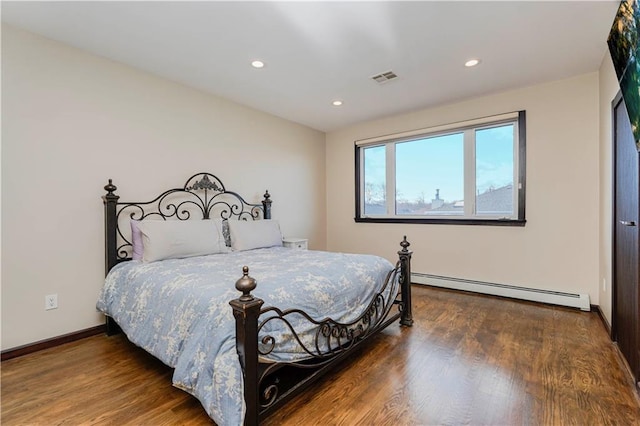 bedroom featuring a baseboard radiator, visible vents, wood finished floors, and recessed lighting