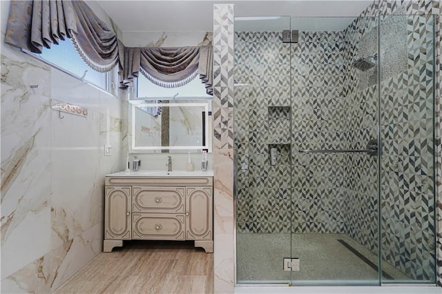 bathroom featuring a stall shower, vanity, and wood finished floors